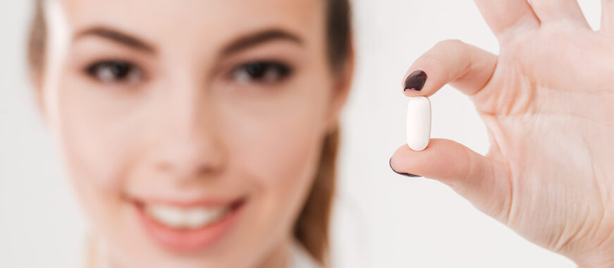 Woman Doctor holding large white Pill in her Hand